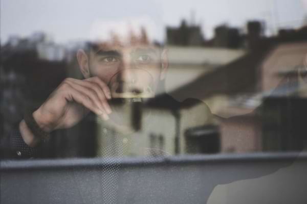 Un homme qui regarde par une fenêtre faisant le vide intérieur