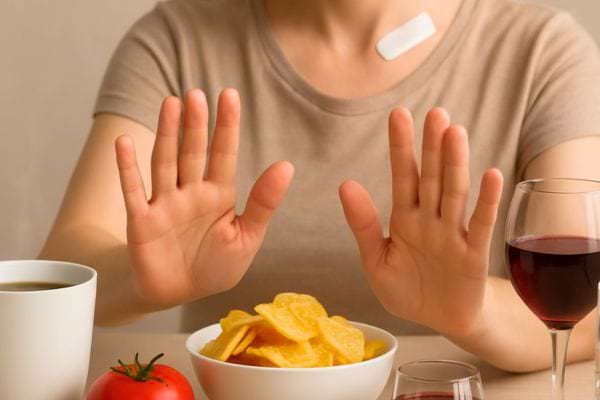 Une personne repousse des aliments irritants posés devant elle.