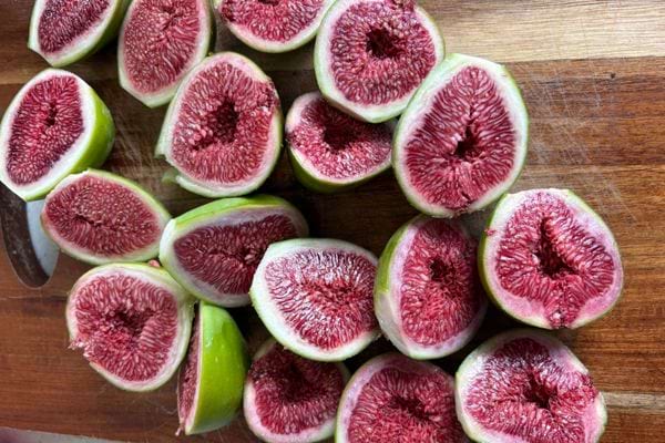 Figues vertes coupées en deux révélant leur intérieur rouge.