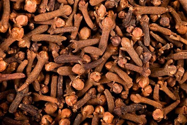 Vue rapprochée d’un grand nombre de clous de girofle secs et entiers.