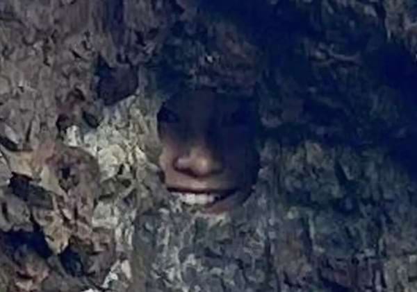 Gros plan de la solution du défi visuel qui consiste à trouver une fille cachée dans un photo d'un rocher