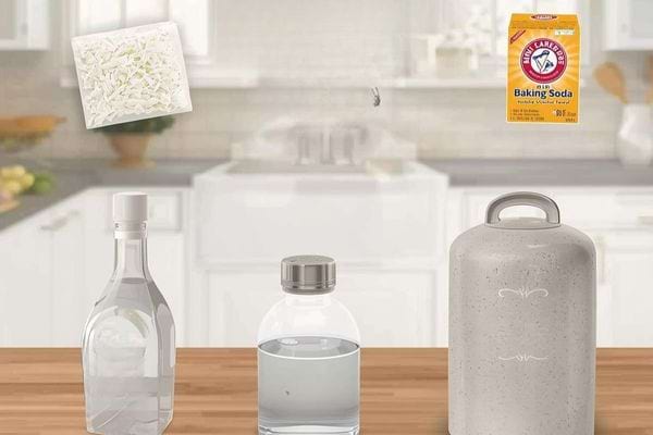 Bouteilles et poudres naturelles sur un plan de travail pour fabriquer une lessive maison.