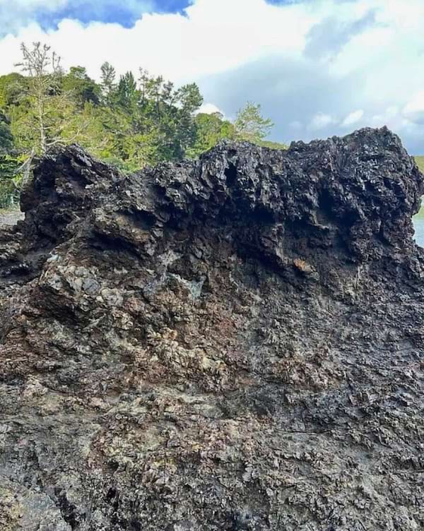 Une photo d'un rocher où se cache une fille.