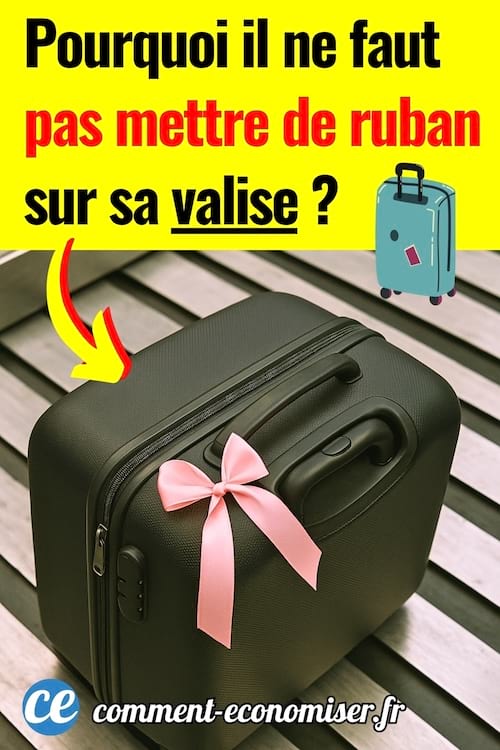 Une valise noir avec un ruban rose à l'aéroport