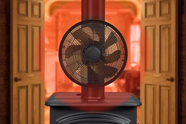 Ventilateur noir sur poêle rouge diffusant la chaleur dans une pièce ouverte