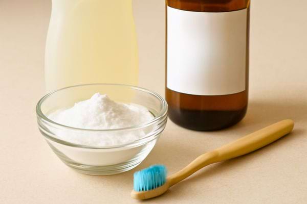 bol de bicarbonate bouteille et brosse a dents montrant une preparation de nettoyage maison