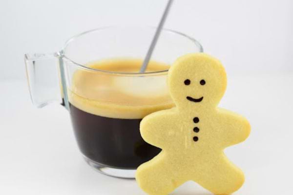 un sablé aux amandes en forme de petit bonhomme devant un café