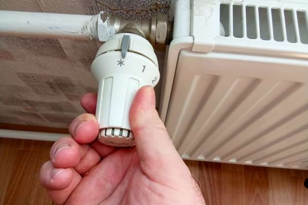 Une personne qui éteint un radiateur