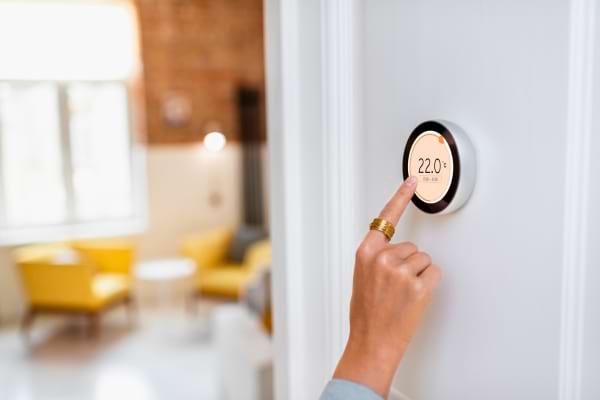 une femme qui règle son thermostat