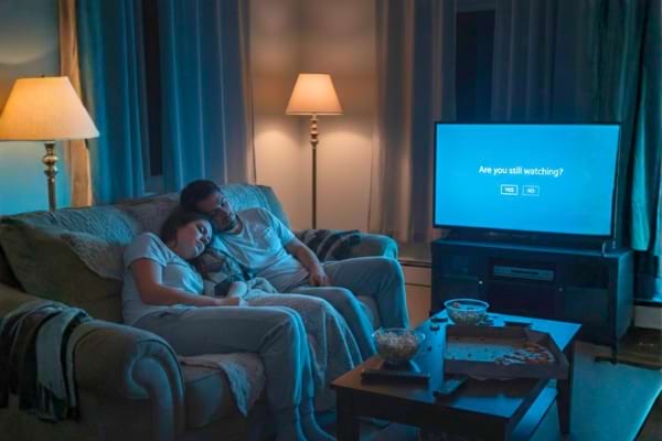 Un couple qui s'endort sur un sofa trop fatigué pour avoir des relations