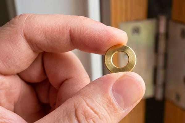 Une rondelle de laiton qui permet de ne plus faire grincer une porte qui racle le sol