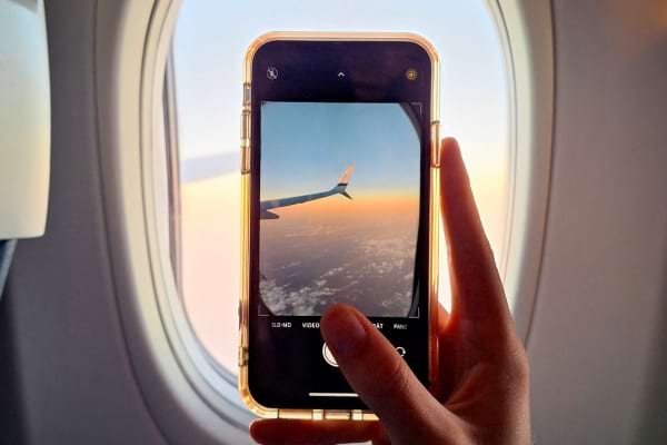 Quelqu'un qui film l'aile d'un avion en plein vol pour montrer qu'il part en vacances