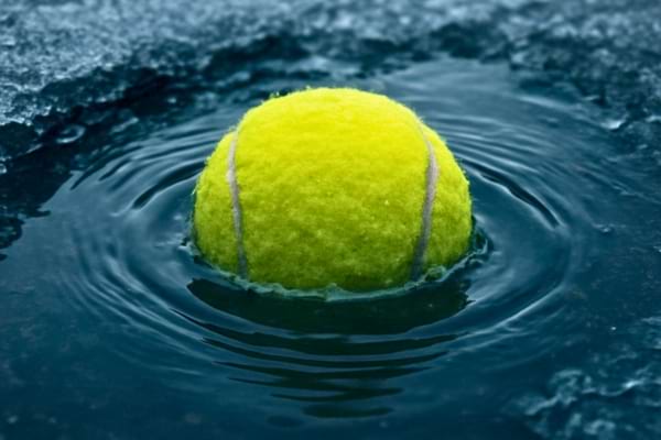 Gros plan niveau de l'eau sur une balle de tennis jaune vif flottant