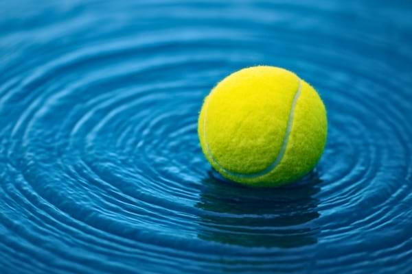 Photo macro artistique montrant le mouvement de l'eau. Une balle de tennis flotte