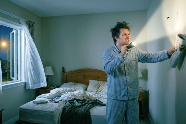 une personne en pleine nuit chercher un moustique qui l'empeche de dormir