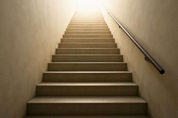 Un escalier montant vers une forte lumière symbolise l’espoir, l’elevation, la reussite et un nouveau depart.