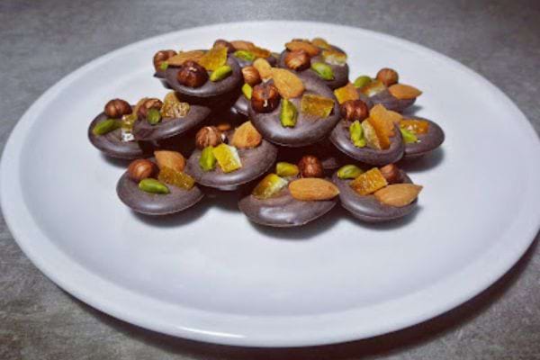 mendiants au chocolat avec des fruits secs et des fruits confits pour Noël