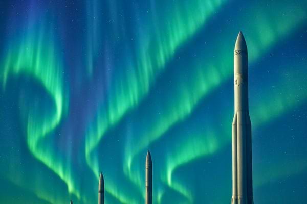 Des missiles se dressent sous un ciel d’aurores vertes vives illuminant la nuit.