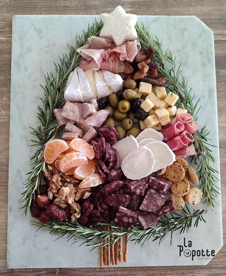 planche ap&eacute;ro de No&euml;l sur une planche de marbre avec des branches d'arbre