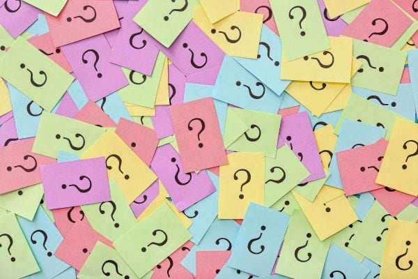 ensemble de post it colores recouverts de points interrogation illustrant confusion curiosite et choix multiples