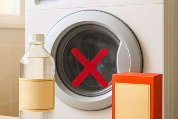 Une bouteille transparente et une boîte orange sont posées devant une machine affichant une croix rouge.