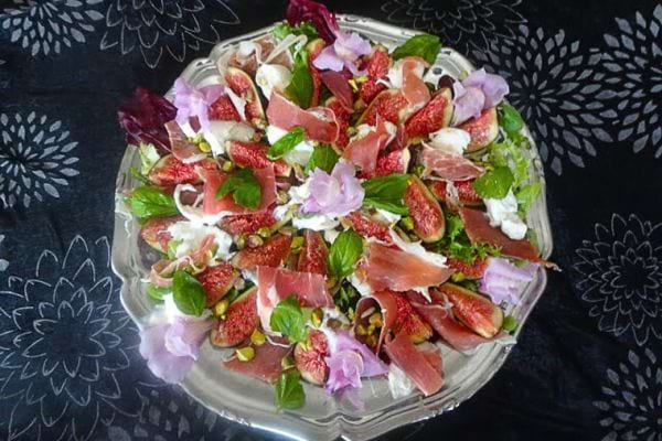 une salade italienne avec du jambon de parme, des figues, de la burrata