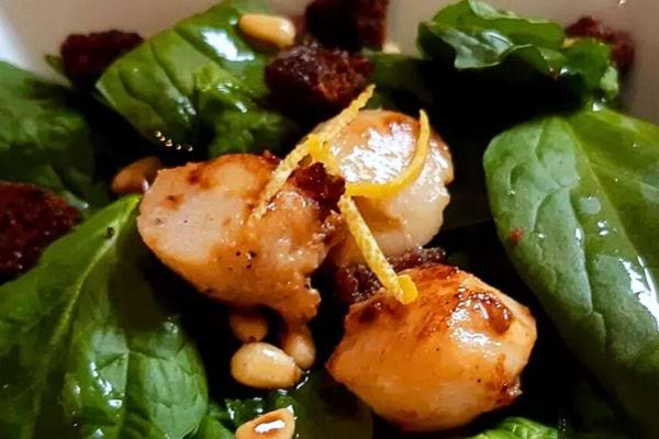 une salade d'épinards et noix de saint Jacques