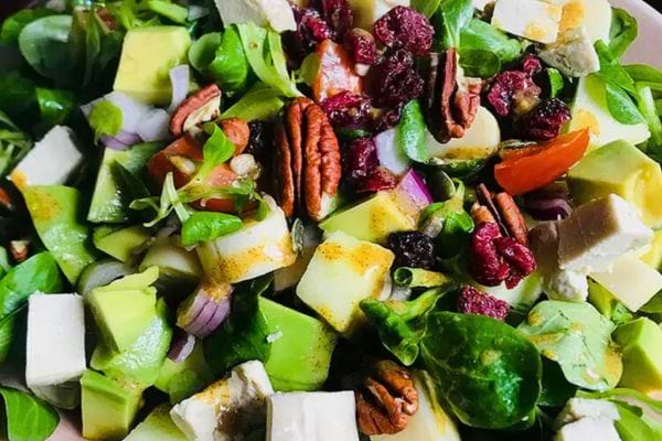 une salade vegan avec de la mâche, des noix de pécan, de l'avocat
