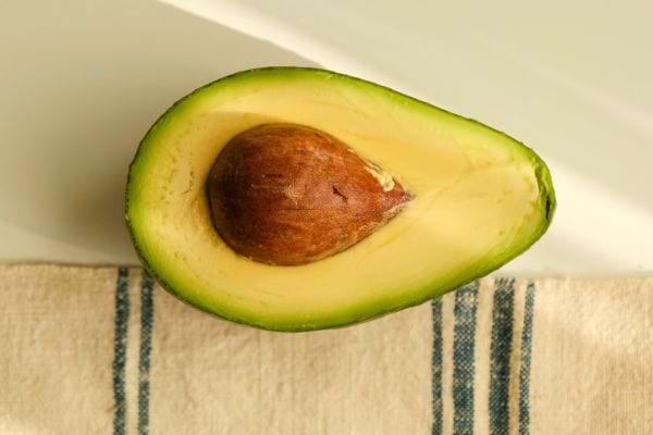 demi avocat coupe avec noyau apparent pose sur torchon clair