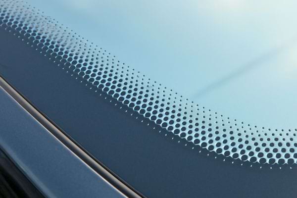 detail de la bande noire pointillee sur le verre du pare brise sous la lumiere