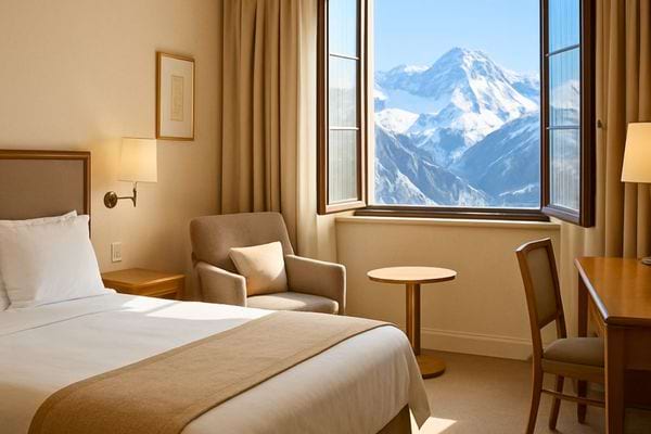 Une chambre d hotel offre une vue degagee sur les montagnes enneigees au loin.