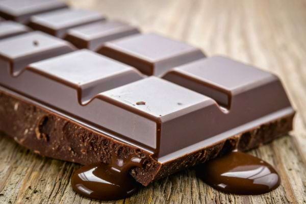 tablette de chocolat noir fondante avec carreaux et chocolat qui coule