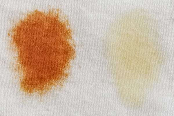 Deux zones de tissu montrent une tache foncee avant nettoyage et une zone claire apres traitement.