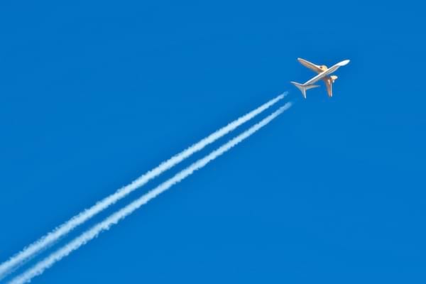 ciel bleu intense, avion de ligne tr&egrave;s haut en altitude, une tra&icirc;n&eacute;e blanche fine