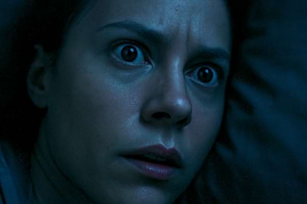 ros plan intense sur le visage d'une personne allong&eacute;e sur un oreiller dans la p&eacute;nombre, qui ouvre brusquement les yeux