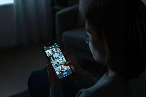 Une femme tient son smartphone, l'écran montre une galerie de photos