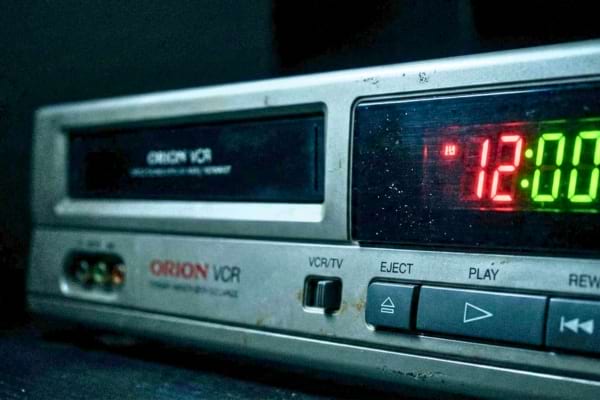 Gros plan sur la fa&ccedil;ade d'un magn&eacute;toscope VCR avec l'heure num&eacute;rique 12:00 qui clignote