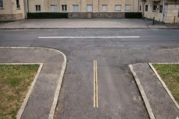 un carrefour en T en zone urbaine, marquages discrets