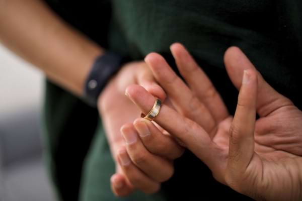 un homme qui enl&egrave;ve discr&egrave;tement sa bague de mariage