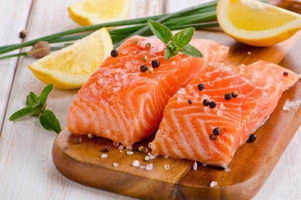 filets de saumon cru avec citron herbes et gros sel sur planche