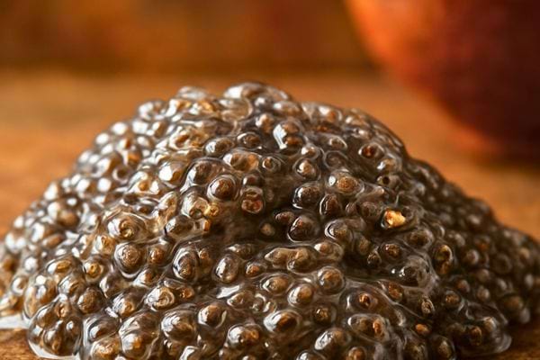 Un tas de graines de chia hydratees est montre en gros plan. La texture epaisse est mise en valeur.