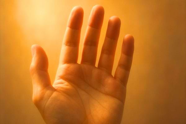 Main ouverte levee vers une lumiere chaude, ambiance douce et apaisante.