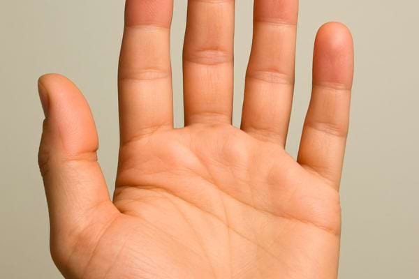 Paume de main ouverte en gros plan, lignes visibles, fond neutre et lumineux.