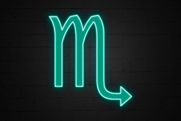 Le symbole du scorpion en neon vert ressort sur fond noir. Il evoque intensite et mystere.