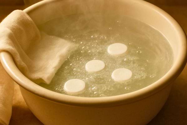 bassine deau chaude avec pastilles blanches et tissu trempe a cote