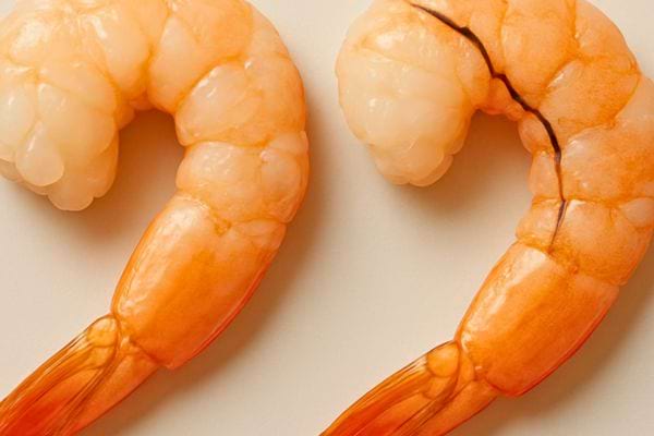 deux crevettes cuites roses alignees montrant une difference de texture sur la chair