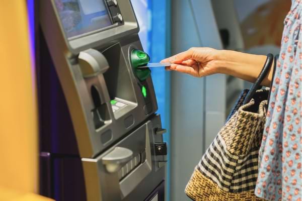 une personne qui retire de l'argent au distributeur