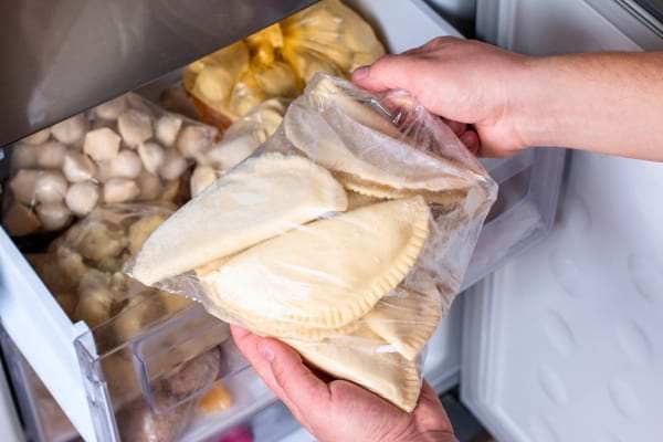 'un cong&eacute;lateur domestique ouvert, tiroirs bien rang&eacute;s. On voit des sacs de cong&eacute;lation transparents