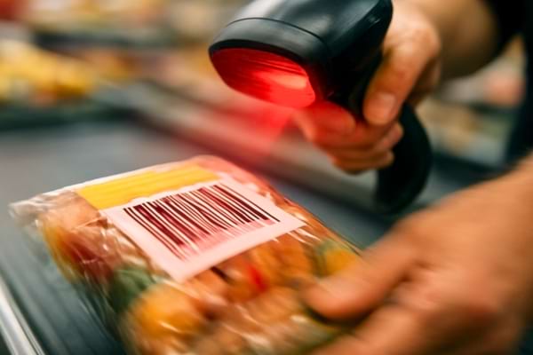 mains d'une caissi&egrave;re scannant tr&egrave;s rapidement des produits alimentaires,