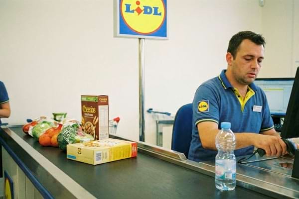 Une bouteille d'eau &agrave; cot&eacute; d'un caissier de chez Lidl